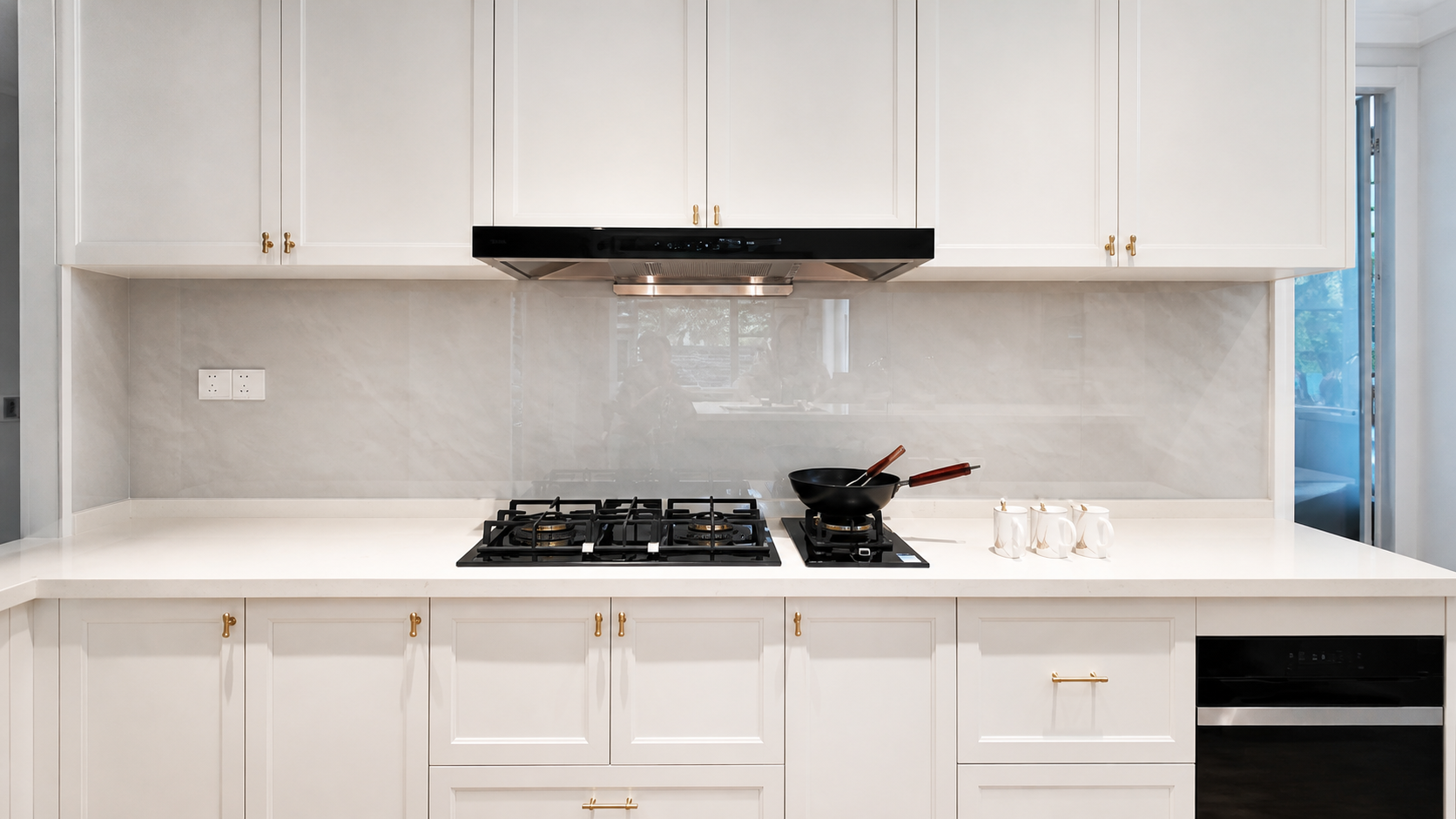 linear kitchen with a gas cooktop, range hood and full-height cabinetry, showing a practical example related to post-install cabinet repair