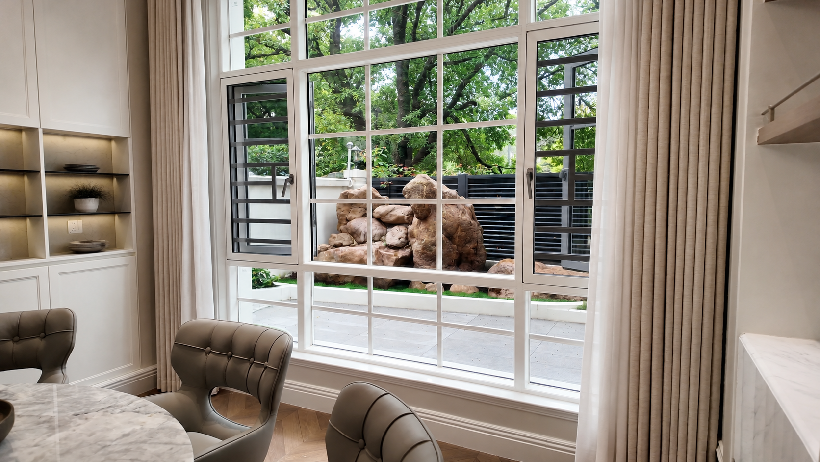 Aluminum picture window framing a garden view in a living room — context for Why does condensation form on my windows every morning?